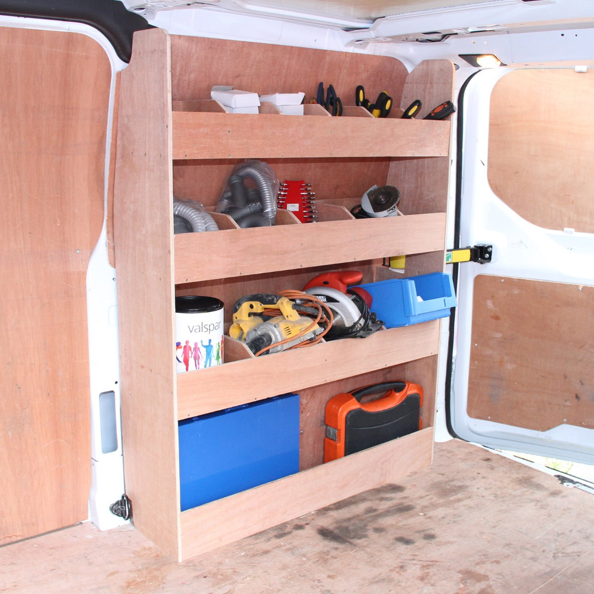 Holzregal für Ford Transit mit drei offenen Regalen, gefüllt mit Werkzeugen, Kisten und Zubehör, auf einem hellen Holzuntergrund montiert