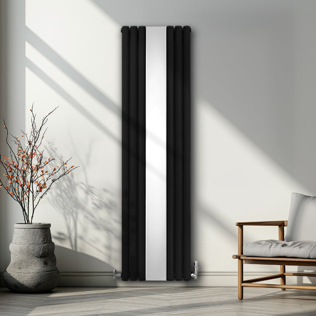 Schwarzer ovaler Röhrenheizkörper mit integrierter Spiegeloberfläche und Chrom-Thermostatventilen, elegant in modernem Raum mit natürlichem Licht