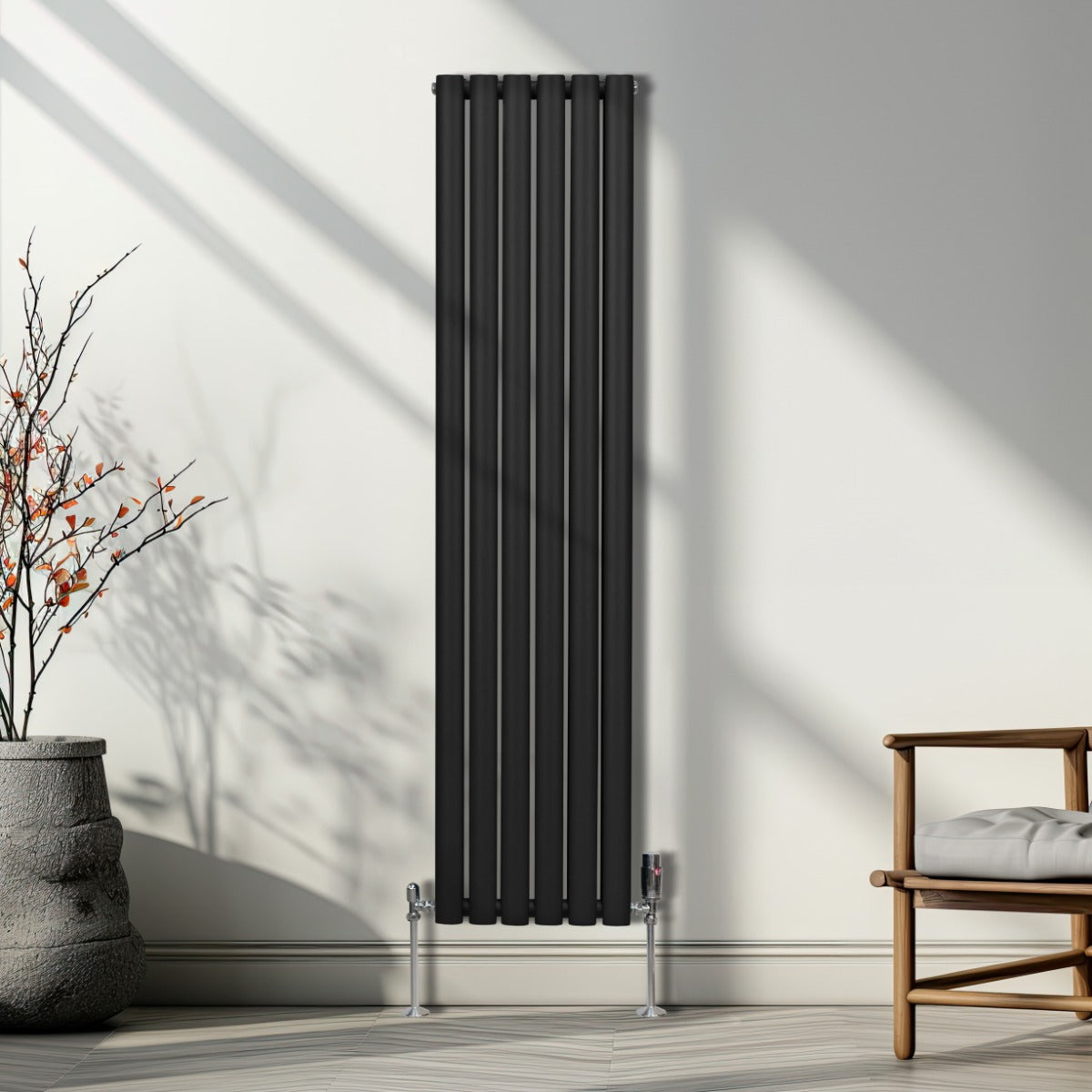 Schwarzer ovaler Röhrenheizkörper mit Chrom-Thermostatventilen, 1600mm x 360mm, elegant an einer Wand montiert, umgeben von natürlichem Licht