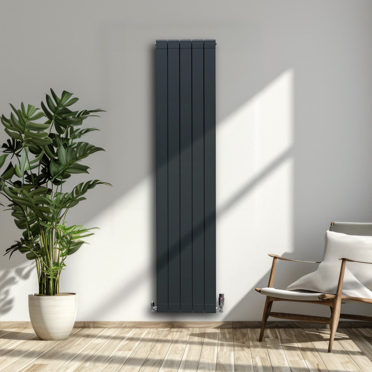 Anthrazitgrauer Aluminium Paneelheizkörper mit vertikalen Lamellen, kombiniert mit Chrom Thermostatventilen, in modernem Wohnraum mit Pflanzen und Holzfußboden