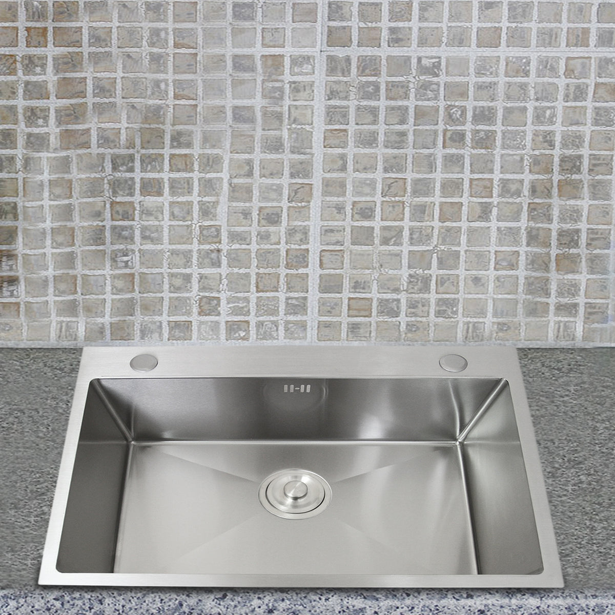 Edelstahl Küchenspüle mit quadratischem Becken, glänzender Oberfläche und abgerundeten Ecken, vor einem hellen, mosaikartigen Fliesenhintergrund