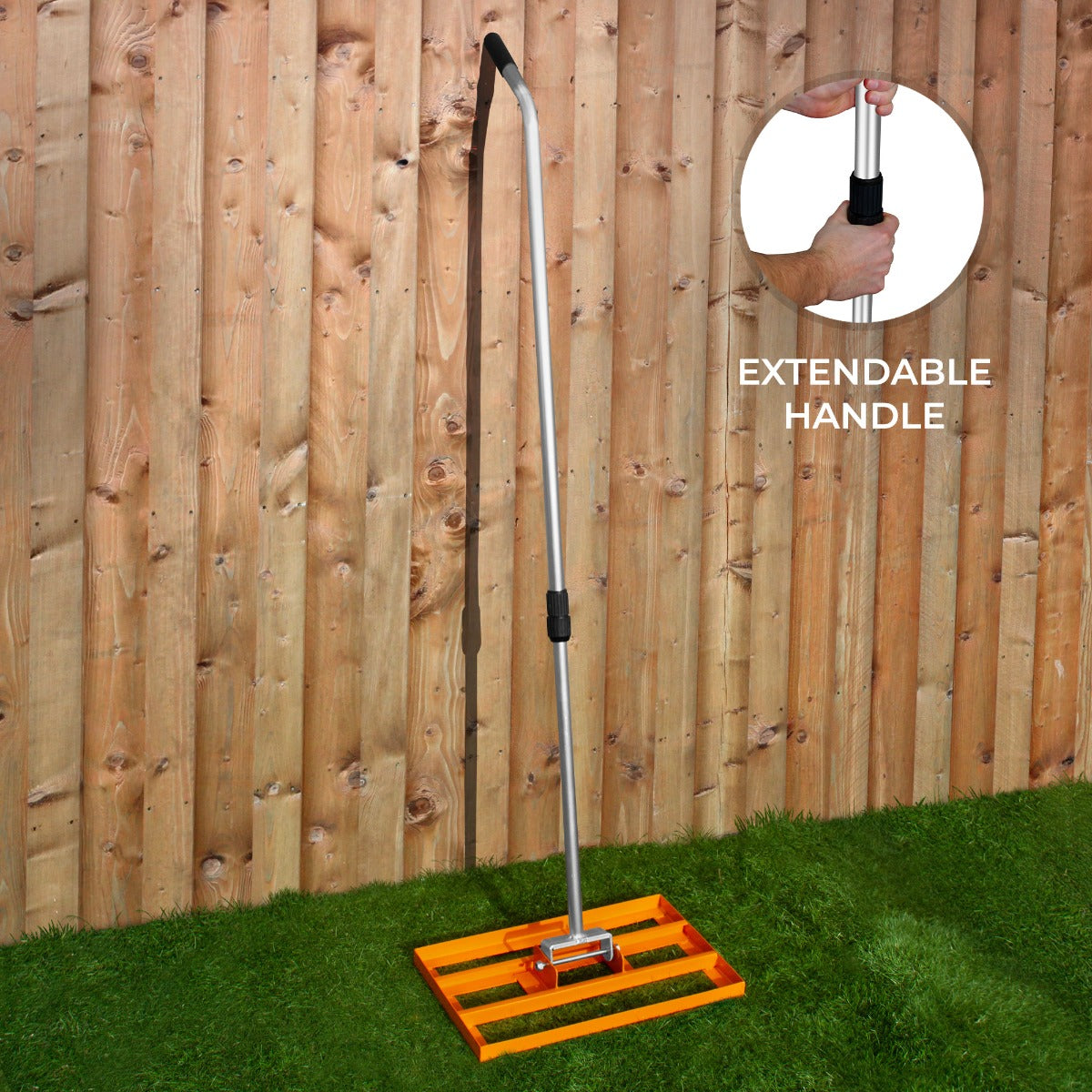 Rasenrakel in leuchtendem Orange mit verstellbarem Aluminiumgriff, ideal für die Pflege von Rasenflächen, auf grünem Gras vor einer Holzlattenwand