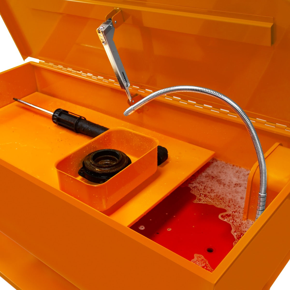 Teilewaschgerät in leuchtendem Orange mit 180L Fassungsvermögen, ausgestattet mit einem flexiblen Schlauch und Reinigungszubehör in einer praktischen Anordnung