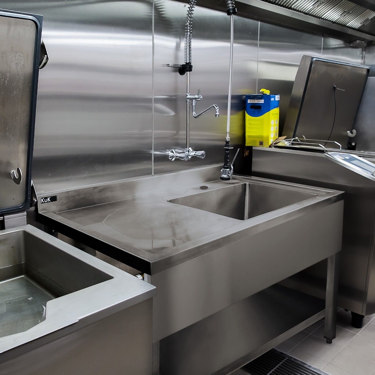 Edelstahl Gastrospüle mit einem großen Becken auf der rechten Seite, glänzende Oberfläche, robustes Design, ideal für gewerbliche Küchen