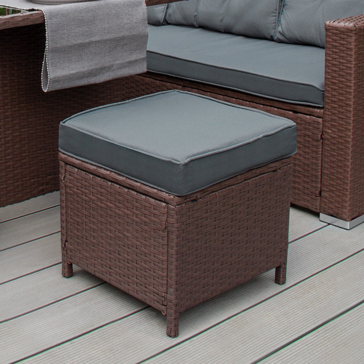 Braunes Polyrattan Gartenmöbel Set mit grauem Kissen, quadratischem Hocker und komfortablem Sofa, ideal für entspannte Stunden im Freien
