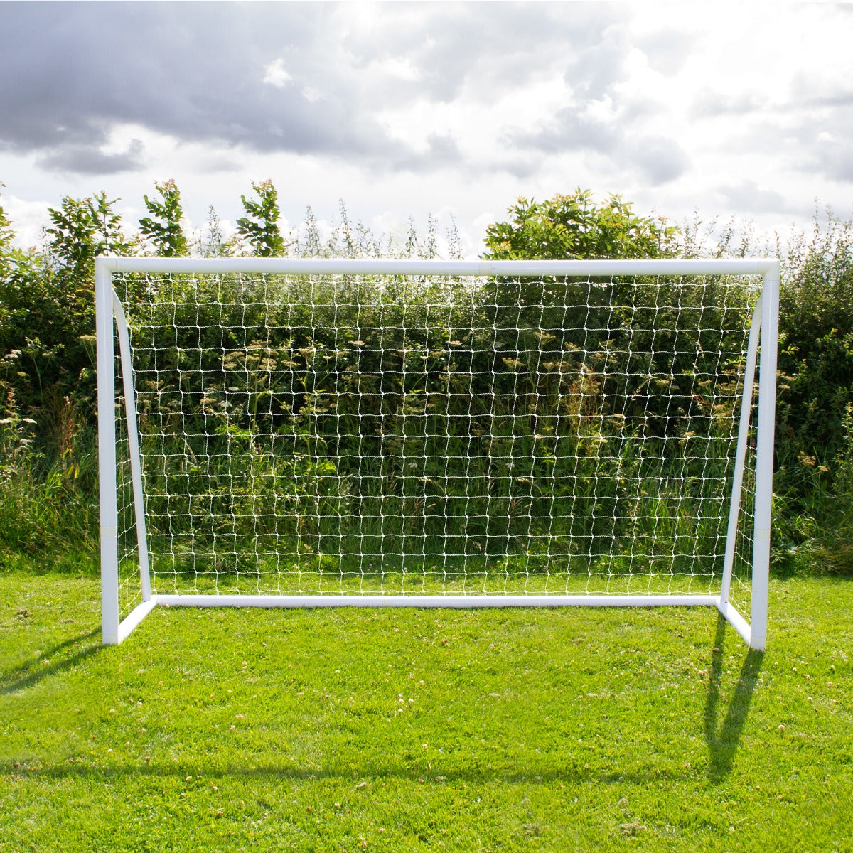 Fußballtor in Weiß mit Netz, 3,6m x 1,8m, auf grünem Rasen, umgeben von Bäumen und einem bewölkten Himmel, ideal für Outdoor-Spiele