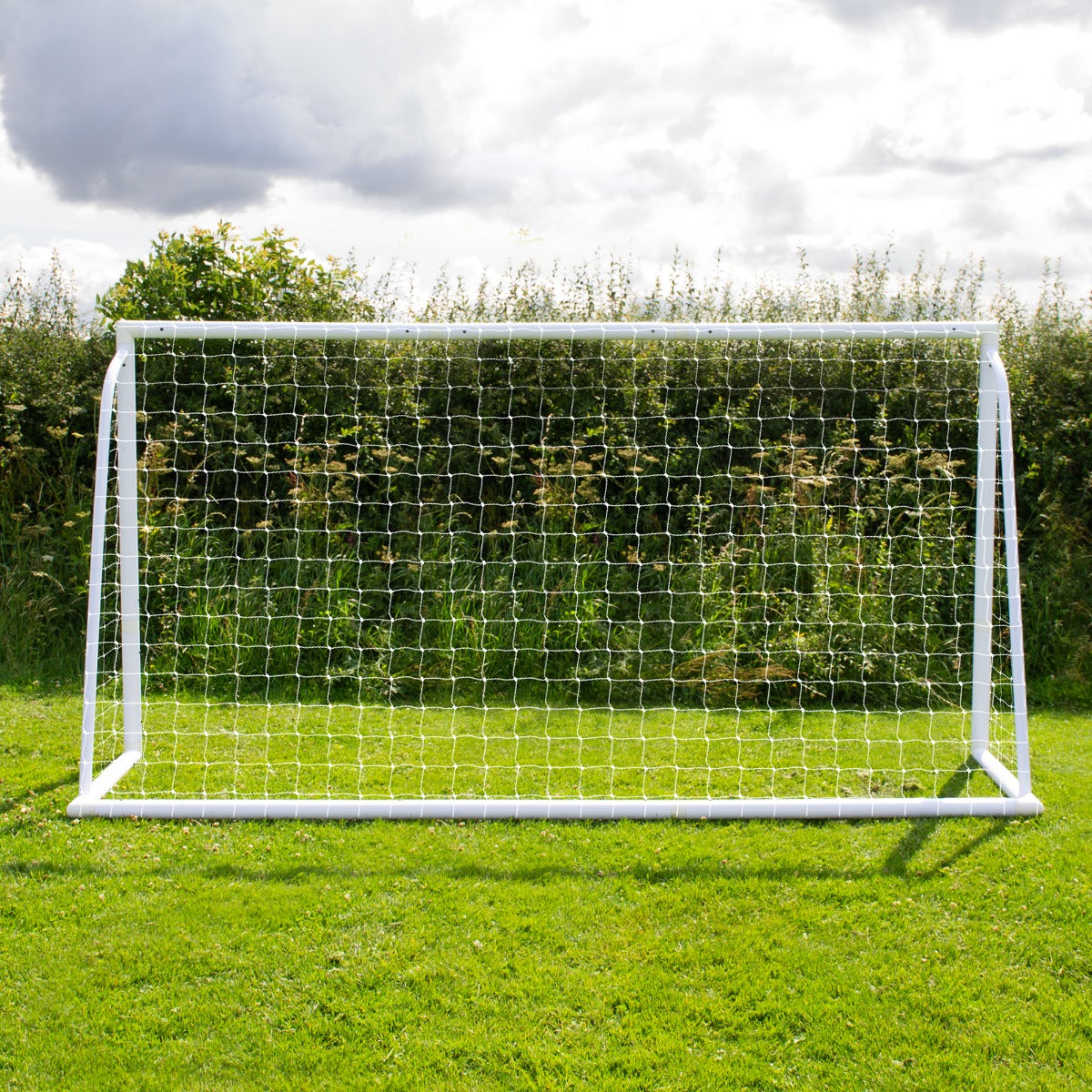 3,6m x 1,8m Fußballtor aus robustem Kunststoff mit weißem Netz, auf grünem Rasen, umgeben von Bäumen und Sträuchern im Hintergrund