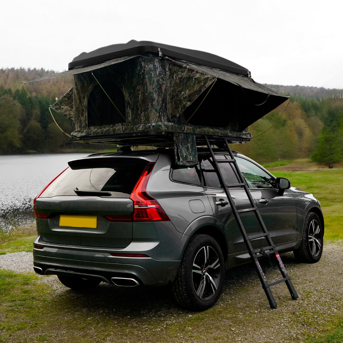 Dachzelt in Camouflage-Design auf einem SUV, mit einer stabilen Leiter, umgeben von Wald und Wasser, ideal für Outdoor-Abenteuer