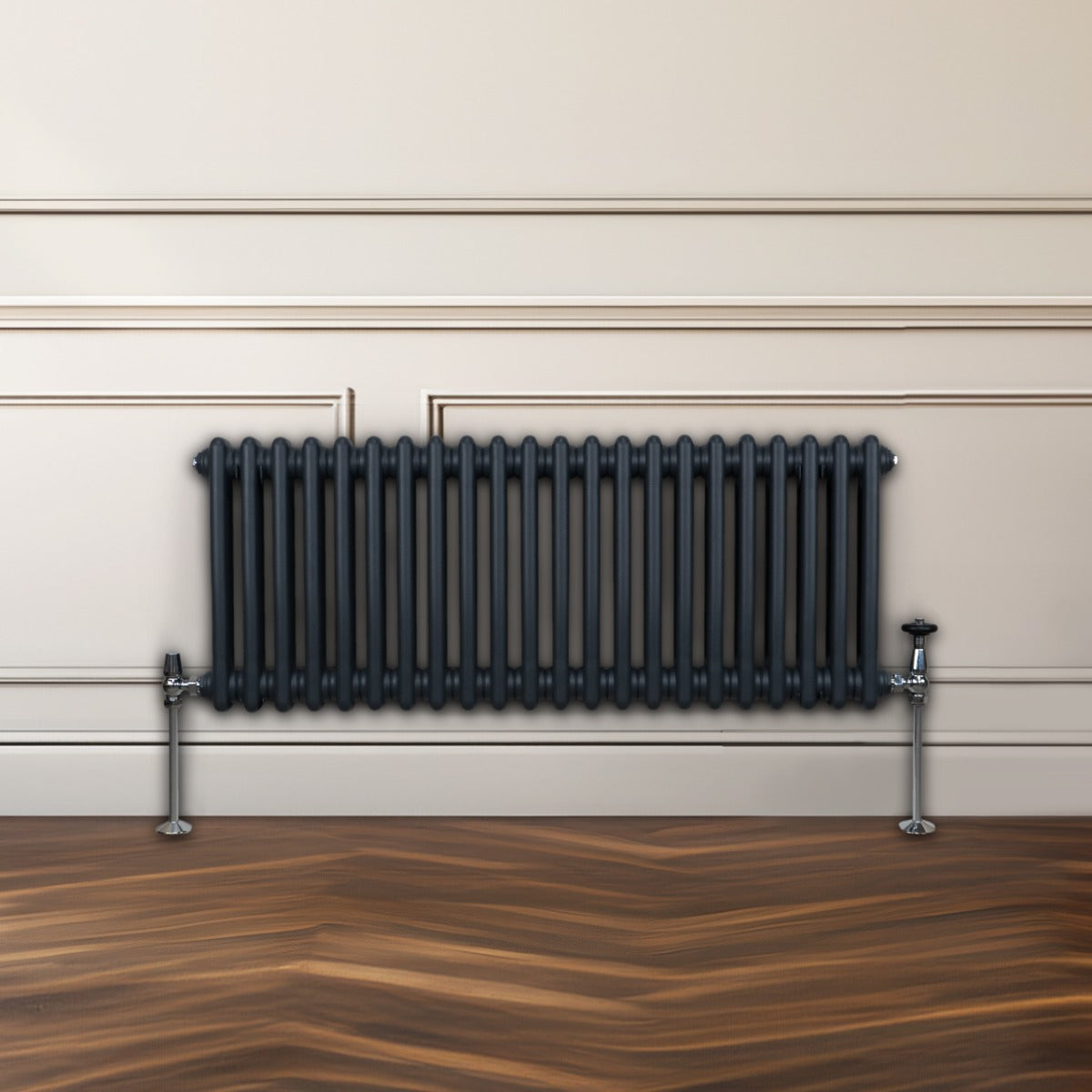 Traditioneller 2-Spalten-Heizkörper in Anthrazitgrau, 300 x 1012 mm, mit glänzenden Metallfüßen, vor einem hellen Wandpaneel und einem Holzfußboden