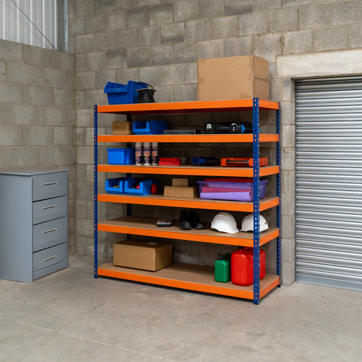 Robustes S-Rax Regal mit 6 Böden in Orange und Blau, gefüllt mit Werkzeugen, Kisten und Sicherheitshelmen, ideal für Lagerung und Organisation