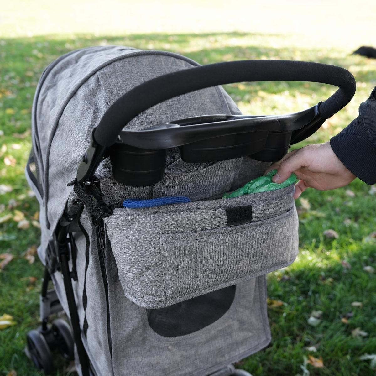 Haustierwagen mit grauer, gewebter Fronttasche, die praktische Aufbewahrung für Zubehör bietet, auf grünem Gras platziert