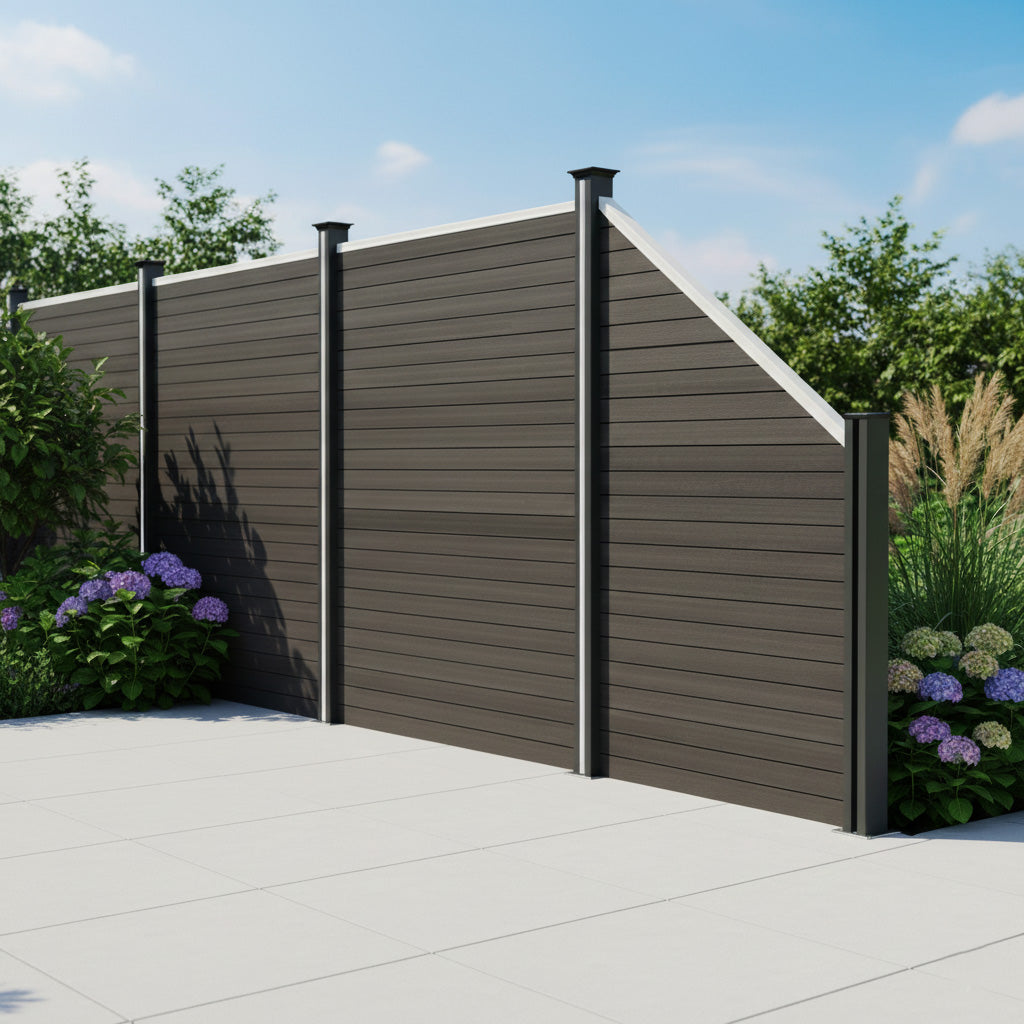 WPC Sichtschutzzaun Eckzaun Element in Grau mit glatter Oberfläche, stabilen Pfosten und modernen, schrägen Linien, umgeben von grünen Pflanzen und Blumen