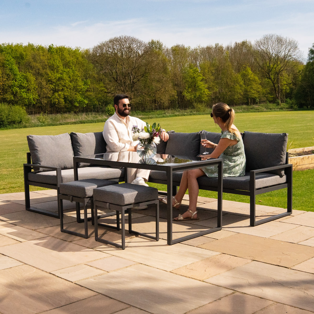 Anthrazitgraues Aluminium-Ecksofa-Set mit bequemen grauen Kissen, umgeben von einer grünen Wiese, ideal für entspannte Gartenabende