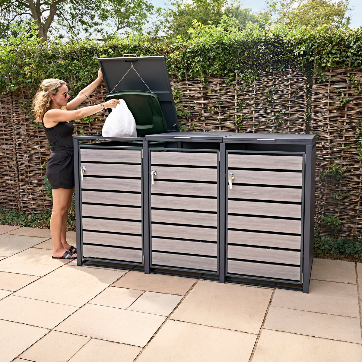Dreifach Mülltonnenbox aus Metall mit grauholzoptischen Türen, robust und modern, ideal für die Aufbewahrung von Abfalltonnen im Garten