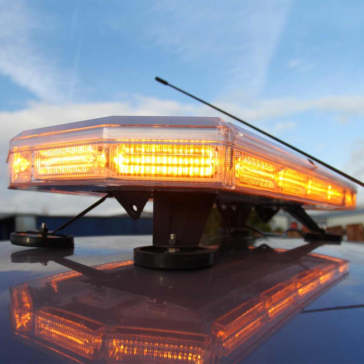 LED Rundumlicht Warnleuchte mit 48 orangefarbenen LEDs, flache rechteckige Form, transparente Abdeckung, montiert auf einem Fahrzeugdach, reflektierender Untergrund