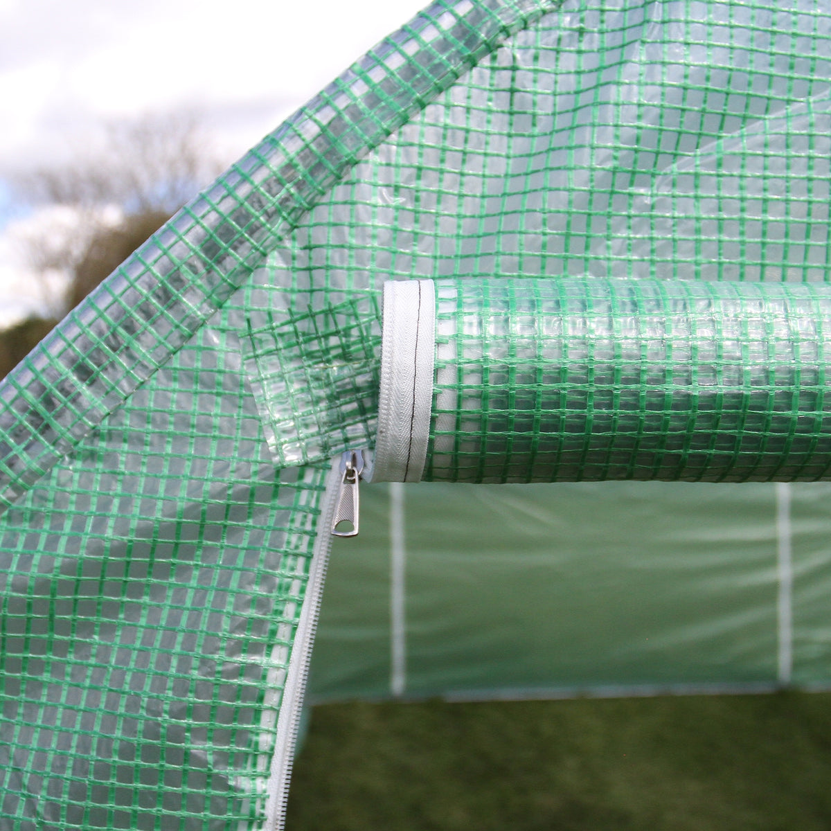 Transparente, grüne Polytunnelfolie mit 25mm dickem Rahmen, zeigt den Reißverschluss und die strukturierte Oberfläche für optimale Stabilität und Lichtdurchlässigkeit