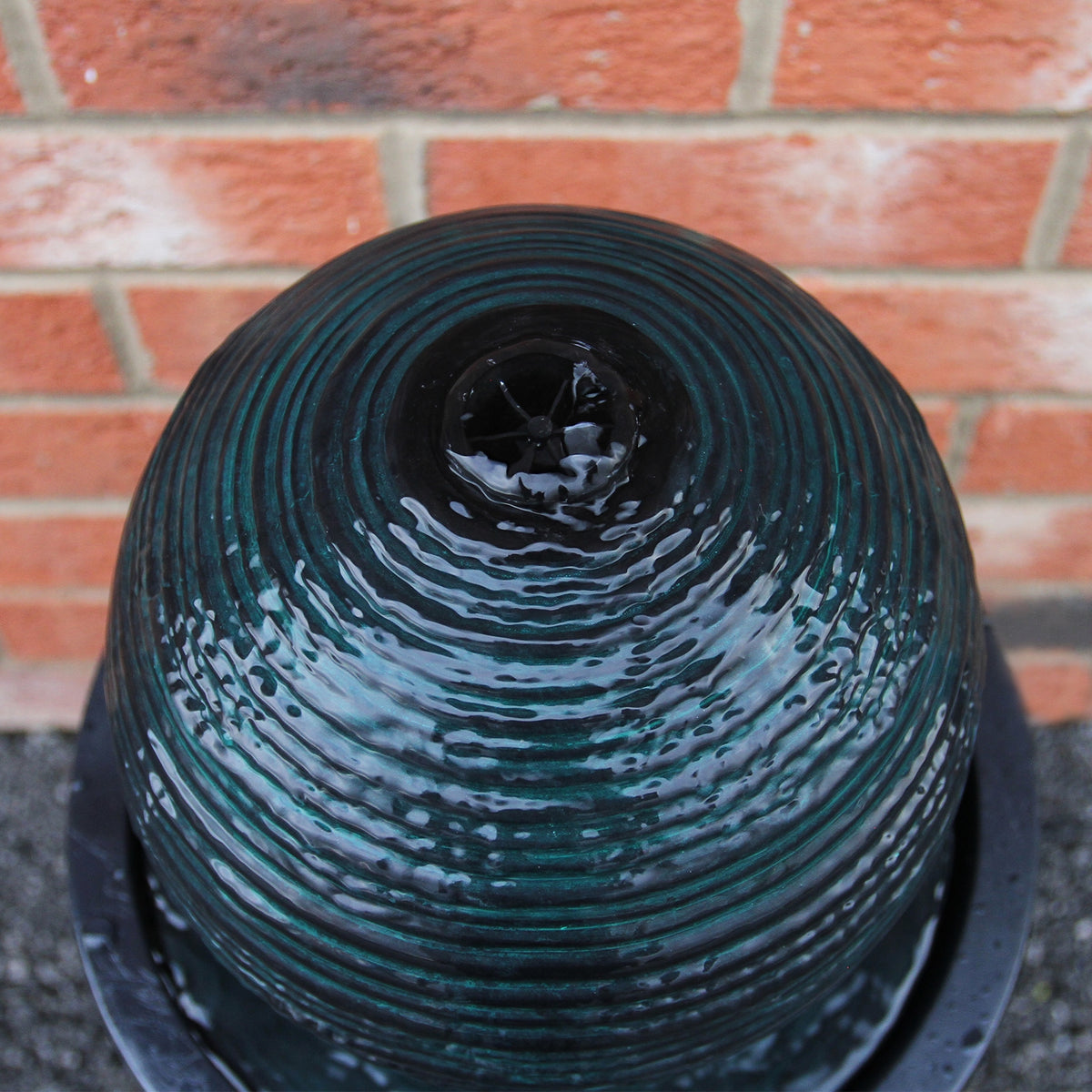 Schwarzer Kugelbrunnen mit gewellter Oberfläche, glänzendem Wasser und runder Form, ideal für Garten- und Terrassengestaltung