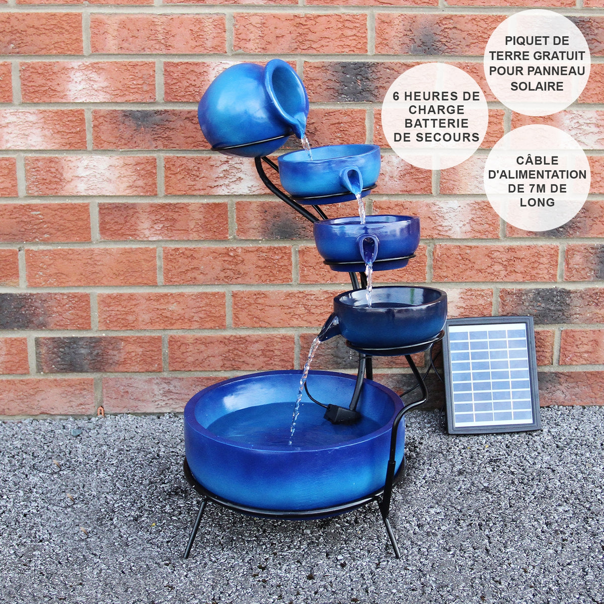 Blauer Solar Kaskadenbrunnen mit Akku, bestehend aus fünf Töpfen, die Wasser in eine große Schale leiten, umgeben von Kies und einem Solarpanel