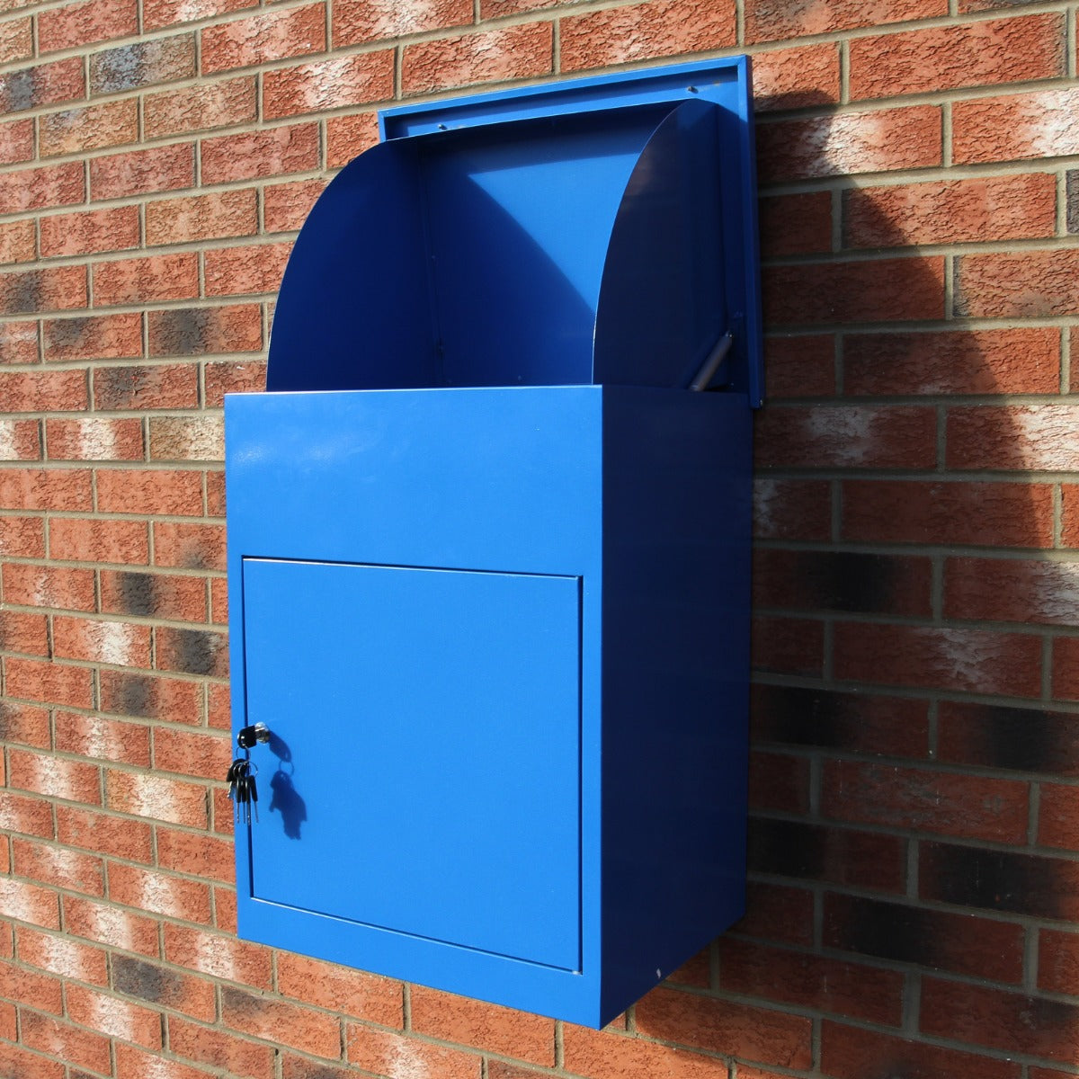 Blauer Paketkasten aus Metall mit glatter Oberfläche, rechteckiger Form und abschließbarem Fach, montiert an einer Ziegelwand