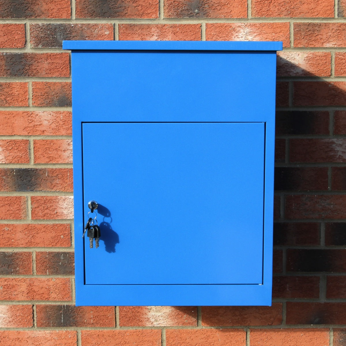 Blauer Paketkasten aus Metall mit glänzender Oberfläche, rechteckiger Form und Schlüsselschloss, an einer roten Ziegelwand montiert