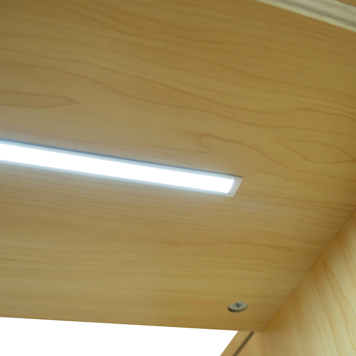Helle LED-Beleuchtung in einer Ahorn-Verkaufstheke, die eine warme Holzmaserung und glatte Oberfläche zeigt, ideal für Verkaufsräume