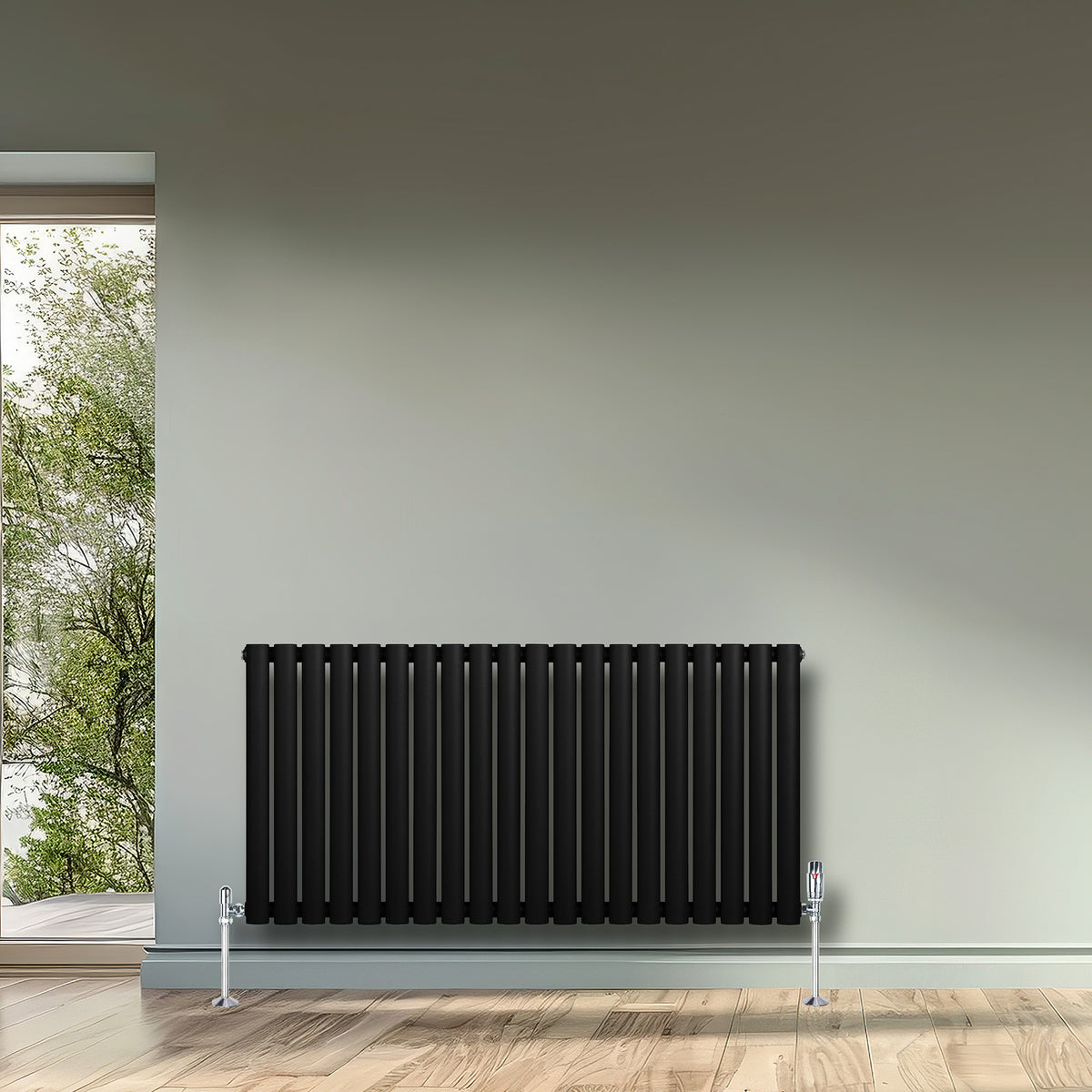 Schwarzer Gliederheizkörper mit TRV Chromventilen, 600mm x 1200mm, elegant an einer hellen Wand, umgeben von natürlichem Licht und Holzfußboden