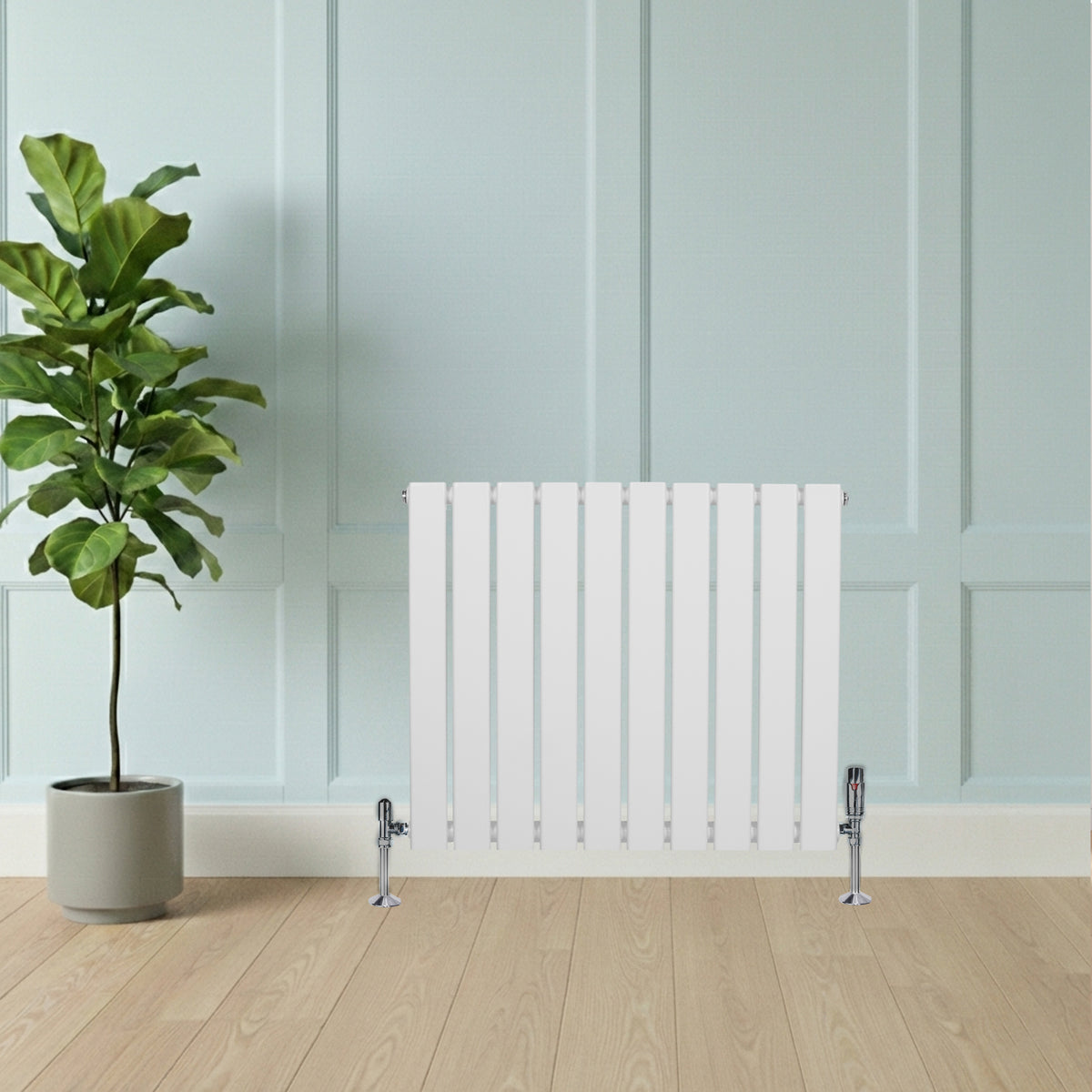 Flachheizkörper in Weiß, 600mm x 700mm, mit geraden Lamellen und modernen Ventilen, vor einer hellen Wand und einem Topf mit grüner Pflanze