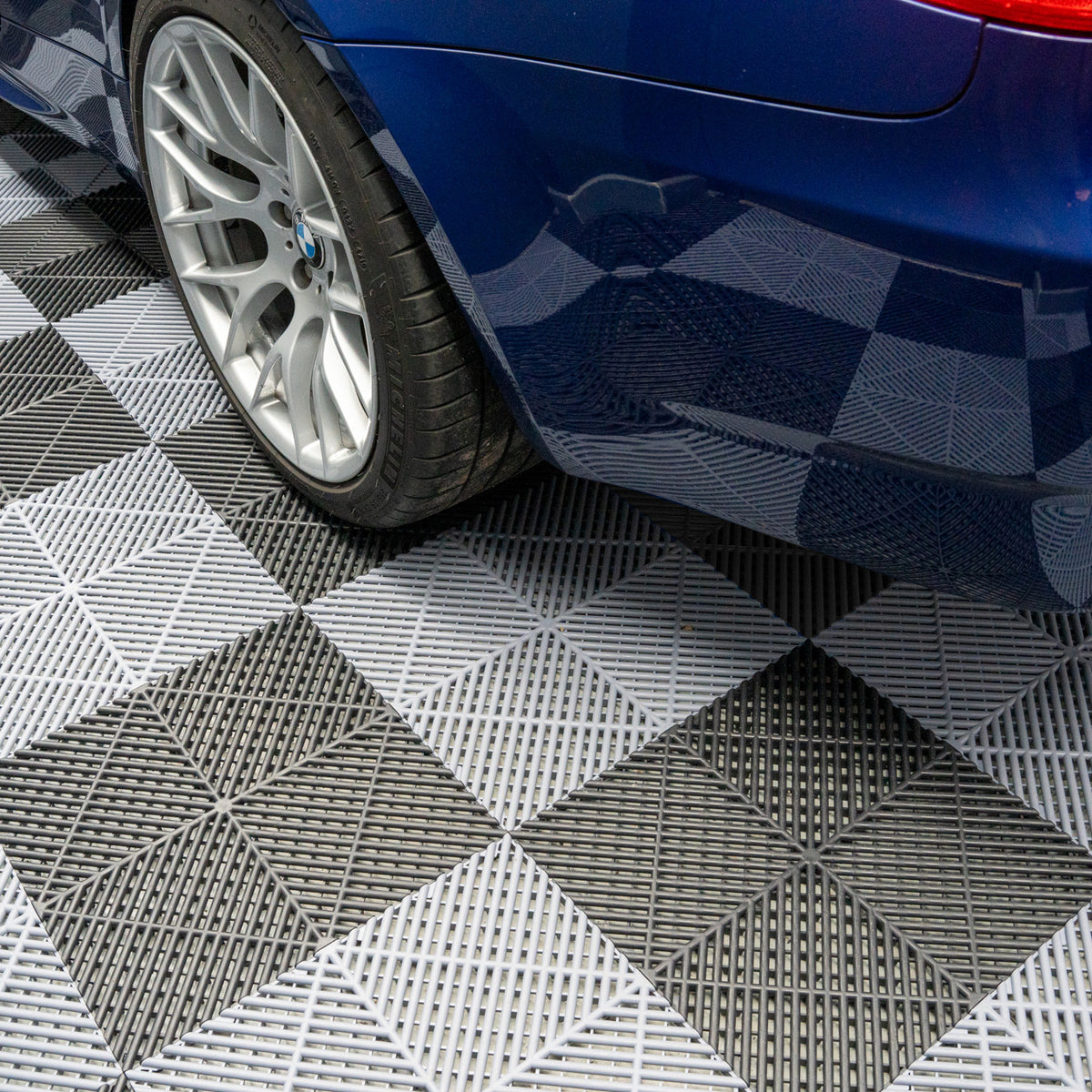 Belüftete Garagenbodenfliesen in Schwarz und Grau, mit rutschfester Oberfläche und diagonalen Mustern, ideal für eine moderne Garage