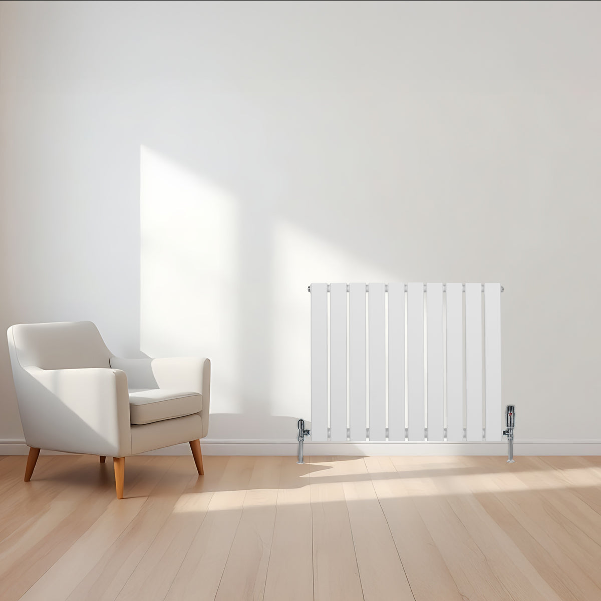 Flachheizkörper in Weiß, 600mm x 700mm, mit schlanken, vertikalen Lamellen und glänzenden Füßen, steht in einem hellen Raum neben einem modernen Sessel