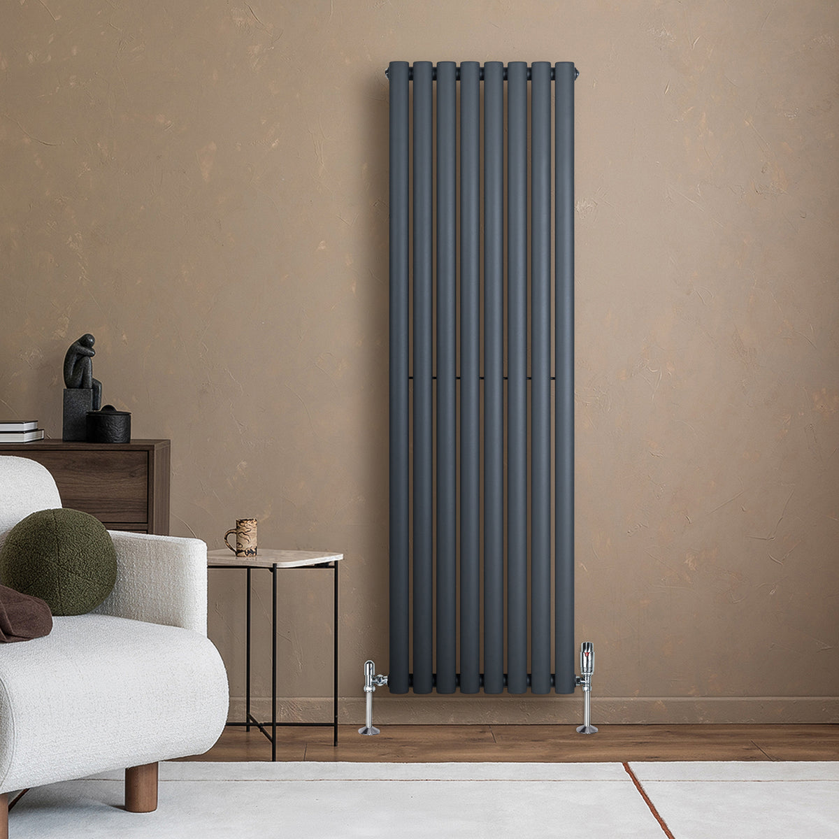 Anthrazitgrauer Gliederheizkörper mit schlankem, vertikalem Design, montiert an einer beige Wand, ergänzt durch moderne Möbel und Dekoration