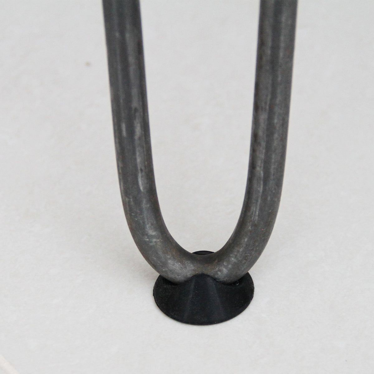 Rohstahl-Hairpin Tischbein mit drei Streben, 71 cm hoch, 12 mm dick, zeigt die geschwungene Form und die schwarze Gummifüße für Stabilität