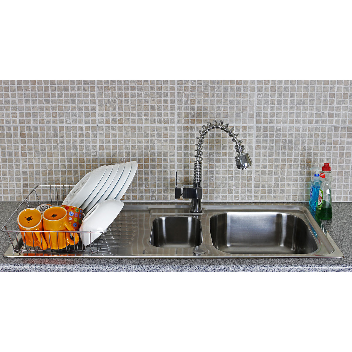 Hochwertige KuKoo Edelstahl-Küchenspüle mit zwei Becken, glänzender Mischbatterie und Geschirr in buntem Abtropfgestell auf grauem Granituntergrund