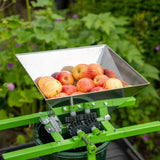Edelstahl Obstpresse mit grünem Gestell, gefüllt mit roten Äpfeln, ideal zum Saftpressen und Zerkleinern von Obst im Garten