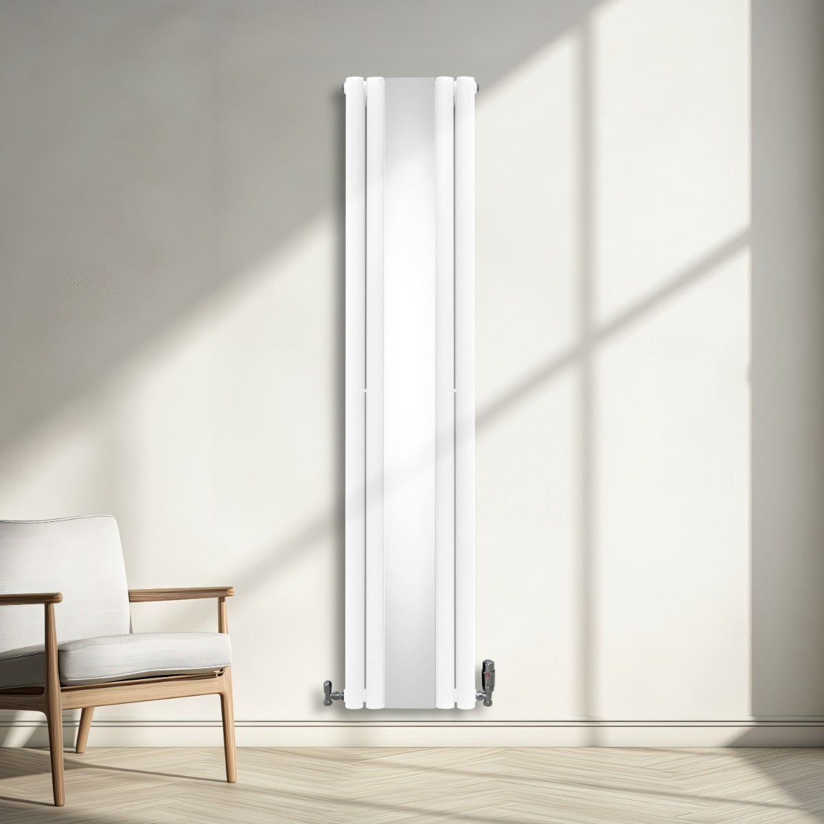 Ovaler Röhrenheizkörper in Weiß mit integriertem Spiegel und Chrom-Thermostatventilen, elegant an einer hellen Wand montiert, umgeben von natürlichem Licht