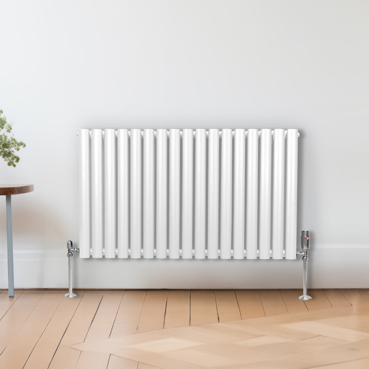 Ovaler Röhrenheizkörper in Weiß mit Chrom-Thermostatventilen, 600mm x 1020mm, auf einem hellen Holzboden, umgeben von einem modernen Raumdesign