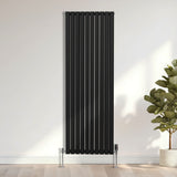 Schwarzer ovaler Röhrenheizkörper mit Chrom-Thermostatventilen, 1800mm x 600mm, vertikal montiert, elegant und modern in einem hellen Raum