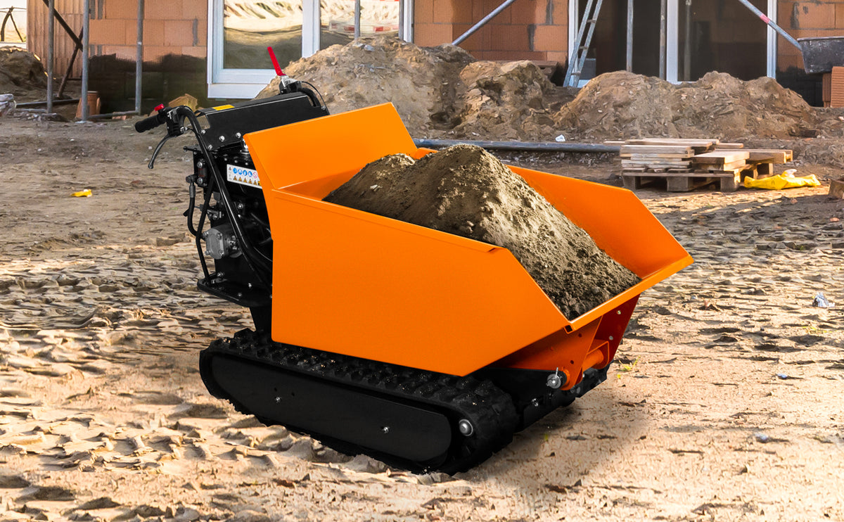 Kompakte, orangefarbene Baustellenmulde mit einem vollen Laderaum aus Erde, auf einem unebenen, sandigen Boden platziert