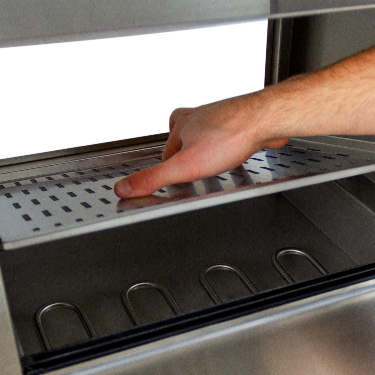 Edelstahl Hot Dog Wärmer mit perforierter Ablage, Hand platziert eine Platte, darunter Platz für Würstchen, modernes und funktionales Design