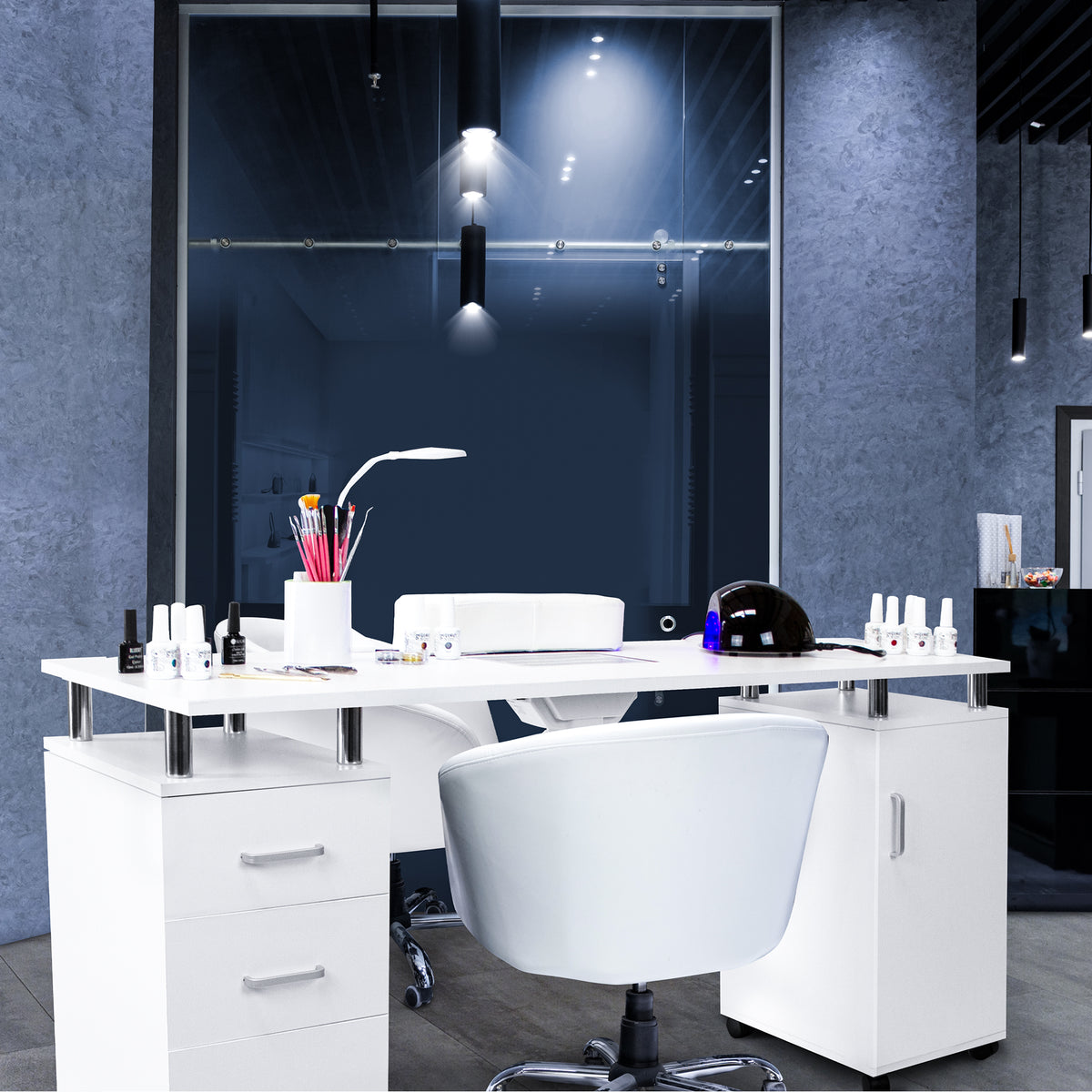 Professioneller Maniküretisch in Weiß mit modernem Design, beleuchtet von Deckenlampen, umgeben von Nagellackfläschchen und Zubehör