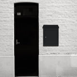 Schwarzer, moderner Anti-Diebstahl Paketkasten aus robustem Material, elegant an einer weißen Ziegelwand neben einer schwarzen Tür montiert
