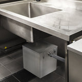 Der KuKoo Gastro Fettabscheider ist ein 35L Edelstahlbehälter, der unter einer Edelstahlspüle montiert ist, mit einem grauen Abflussrohr und glatter Oberfläche