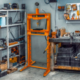 Hydraulische Werkstattpresse in leuchtendem Orange mit Manometer, stabiler Metallrahmen, in einer gut ausgestatteten Werkstatt mit Werkzeugen und Regalen