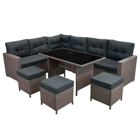 Elegantes Polyrattan Gartenmöbel Set in Grau mit bequemen, dunkelgrauen Polstern, bestehend aus einer L-förmigen Couch und einem Tisch mit Glasplatte