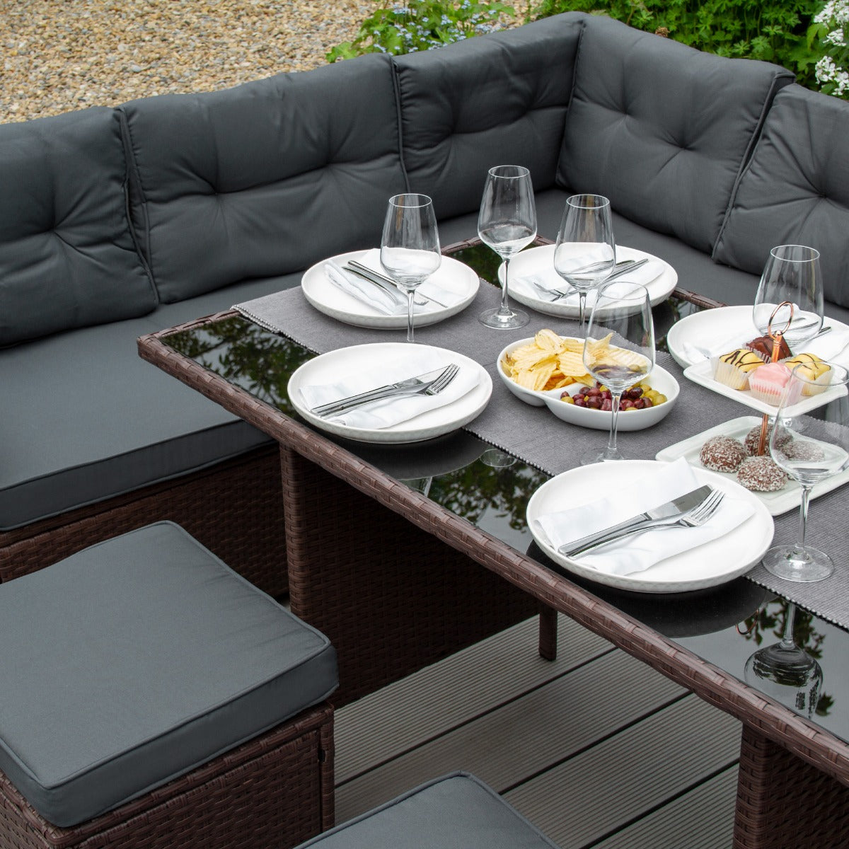 Braunes Polyrattan Gartenmöbel Set mit bequemen, grauen Kissen, einem eleganten Tisch mit Glasplatte und gedecktem Tisch für ein stilvolles Outdoor-Essen