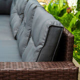 Braunes Polyrattan Gartenmöbel Set mit grauen, gepolsterten Kissen, das eine gemütliche und stilvolle Sitzgelegenheit im Freien bietet
