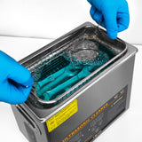Ultraschallreiniger von T-Mech mit blauem Reinigungslösung, Edelstahlbehälter und Werkzeugen, die in Blasen getaucht sind, für effektive Reinigung