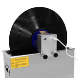 Ultraschall-Schallplattenreiniger in silberner Box mit schwarzer Schallplatte, die auf einem stabilen Halter rotiert, Kabelanschluss sichtbar