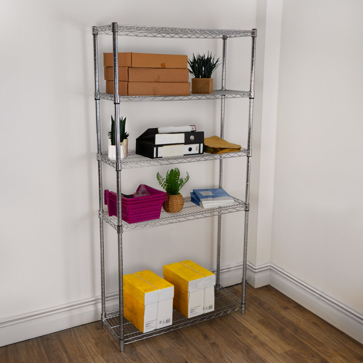 Drahtregal in silber mit fünf Regalböden, gefüllt mit Kisten, Pflanzen und Bürobedarf, auf einem Holzboden in einem hellen Raum