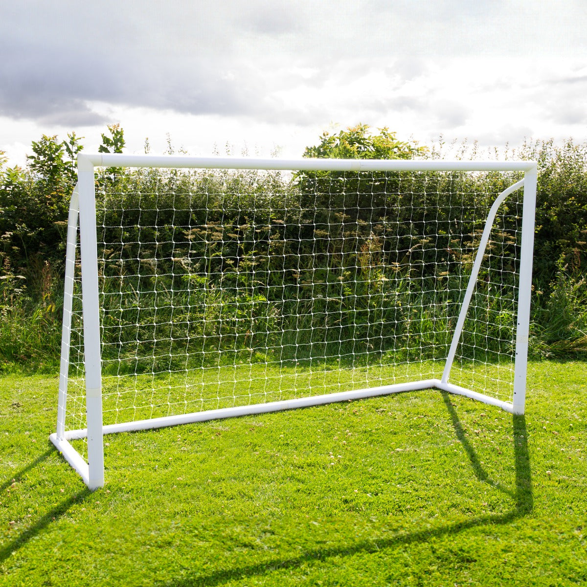 Fußballtor in Weiß mit stabiler Netzstruktur, auf grünem Rasen platziert, ideal für Garten- oder Freizeitspiele, inklusive Tragetasche und Torwand