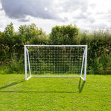 Weißes Fußballtor mit Netz, 1,8m x 1,2m, auf grünem Rasen, umgeben von Bäumen und Sträuchern, ideal für Garten oder Sportplatz